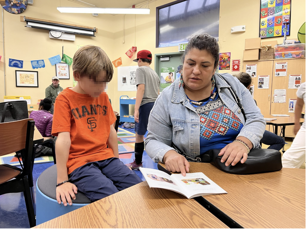 Family volunteer reading with a student